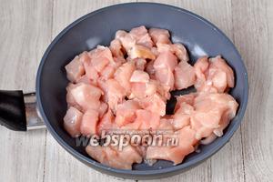 Сначала нужно подготовить куриное филе. Промываем его, нарезаем кубиками, выкладываем на сковороду с маслом.
