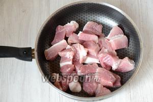 Мясо промываем под проточной водой, затем нарезаем кусочками и выкладываем на раскалённую сковороду с маслом.