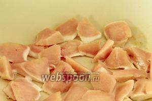 В разогретую сковороду положить 1 ст. л. масла и положить кусочки курицы. Слегка обжарить их, но не пересушите.