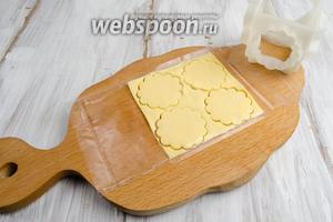 Развернуть упаковку, не снимая её, снизу ломтика сыра. С помощью вырубки нарезать сыр кругами.