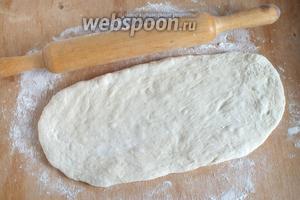 Когда тесто подойдёт, разделите его на 3 части, из всех продуктов как раз получается 3 средних размеров рыбника. Каждую часть раскатайте в овал.