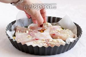 Сверху разложить кусочки маринованной рыбы в чесноке.