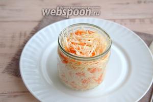 Следующий этап: уложите получившуюся массу в банку, время от времени хорошенько утрамбовывая её толкушкой. Старайтесь вместить как можно больше капустной смеси.