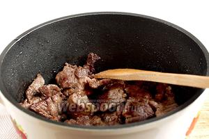 В казане хорошо разогреть растительное масло, выложить мясо и обжарить его на сильном огне до румяной корочки. Пока не солить. Залить водой, примерно 180 мл, убавить огонь до малого и тушить под крышкой до выпаривания жидкости.