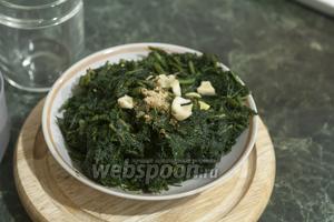 В размороженный отжатый шпинат добавляем кусочки очищенного чеснока и порошок имбиря (можно заменить 1 см свежего корня имбиря).