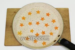 Первый раз можно смазать сковородку подсолнечным маслом. Выкладываем звёздочки в хаотичном порядке.