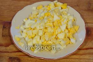 Отварные куриные яйца нарезать кубиком.