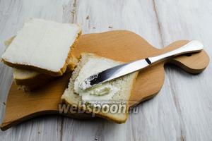 Готовить это блюдо, желательно, в перчатках. Подготовить куски хлеба размером 10х10 см, лишнюю часть отрезать. Равномерно смазать хлеб сыром.