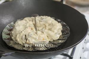 Сворачиваем рулетом, защипнув концы. Формуем кольцом и укладываем на смазанную маслом поверхность пароварки, которую мы установили в воке с кипящей водой.