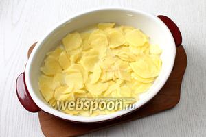 Форму для запекания смазать сливочным маслом. Нарезать тонкими кружками картофель. Я использую для этих целей тёрку для шинковки. Выложить половину в форму.