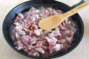 Куриные желудочки продукт не самый нежный, поэтому перед обжариванием и непосредственном приготовлением их нужно потушить. Влейте в сковороду воду или куриный бульон так, чтобы жидкость покрывала кусочки. Доведите до кипения и тушите до тех пор, пока жидкость не испарится, а на сковороде не останется только масло, которое вы добавили на дно. На это уходит примерно 25 минут.