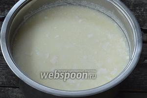 Поставить кастрюлю с подготовленным молоком на кипящую водяную баню и нагревать на очень медленном огне минут 5-6. Начнёт отходить сыворотка и формироваться сгустки творога.