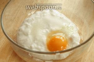В миску положить кисломолочный продукт, соль, сахар, 1 яйцо и масло. Перемешать всё вилкой или венчиком.