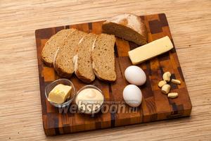 Выложите на стол все необходимые продукты, чтобы было удобно готовить. Возьмём хлеб, сыр, яйца, чеснок и масло сливочное.
