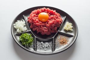 Последний шаг — в мясное «гнездо» выкладывается сырой яичный желток. Вот так выглядит одна порция татарского бифштекса при французском способе подачи. Если предполагается подача для группы гостей, то можно выставить приправы на столе в общих мисочках, а каждому из едоков подать в круглой тарелке сырой фарш с сырым же яичным желтком. Едят это сырым, приправляя по вкусу.