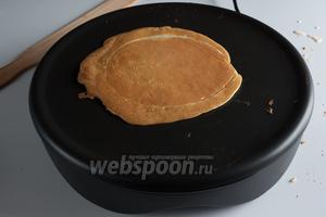 Когда края крепа стали коричневыми, его отделяют от жаровни длинной узкой лопаткой и переворачивают (лопатка видна в левом верхнем углу кадра, в шаге 12 её будет лучше видно). Лопатку считаю замечательным изобретением человечества! Она длинная и прямая, заострена со всех сторон кроме рукоятки, поэтому и подковыривать блин, и переворачивать ею очень удобно. И вообще с жаровни без бортиков крепы поднимать удобнее, чем блины со сковородки. Короче, у меня наконец-то появилась надежда, что удастся мне и блины испечь.