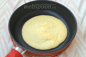 Немного смазать сковороду маслом и вылить около половины теста. Жарить блинчик, пока поверхность покроется мелкими порами и станет сухой.
