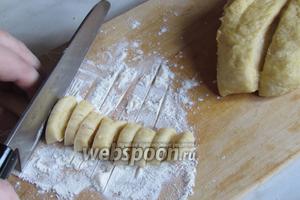 Сделать из них тонкие колбаски и, присыпав мукой, разрезать на мелкие кусочки, затем припорошить в муке.