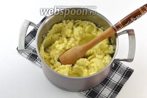 Если картофель готов — всю воду слить. Тщательно размять горячий картофель с помощью толкушки.