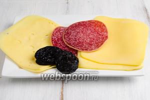 Чтобы приготовить бутерброды, нужно взять в нарезке сыр, предпочтительно, двух сортов, колбасу и вяленый чернослив.