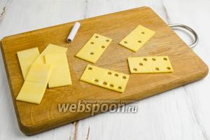 С помощью вырубки малого размера сделать отверстия в двух частях, соответствующие разным комбинациям косточек домино.