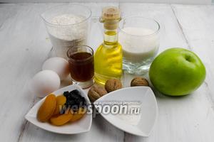 Чтобы приготовить пирог, для теста нужно взять: муку, разрыхлитель, ваниль, яйца, сахар, подсолнечное масло, коньяк, изюм, курагу, яблоки, крахмал; для покрытия : сахар, корицу, орехи, сахарную пудру.