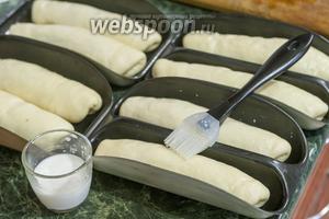Укладываем в смазанные формы наши булки. Смазываем их молоком. Оставляем их подходить, накрыв пекарской бумагой. И разогреваем тем временем духовой шкаф до 190°С.
