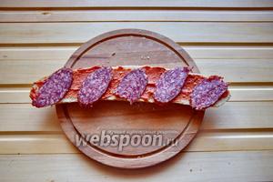 Сверху выложим кусочки тонко-нарезанной сырокопчёной колбасы. Будет здорово, если она окажется чуть островатой!