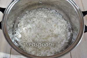 Поставьте кастрюлю с кокосовой стружкой и сахаром на сильный огонь, добавьте воду и, помешивая, дождитесь, когда образуется сироп. Затем можно оставить стружку вариться в сиропе на несколько минут, но не отходите далеко. Нужно следить, чтобы сахар не начал пригорать.