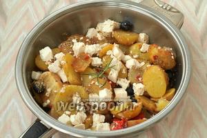 В сковороду вернуть весь обжаренный картофель, добавить Фету или брынзу, а также маслины. Посолить и поперчить, добавить орегано.
