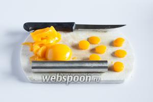 С помощью маленькой круглой контурной формы вырезаем из консервированных персиков цилиндрики — это будут желтки. Я пользуюсь приспособой для вырезания сердцевин яблок. Персики толстые, а желтки нам потребуются достаточно тонкие, так что лучше разрезать их на половинки ножом. Гладкие верхние части (которые были у персиков под шкуркой) откладываем, они нам нужны для декора. Количество желтков должно совпадать с количеством половинок шоколадных яиц.