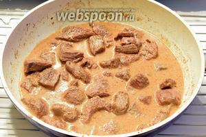 Возвращаем мясо в сковороду, заливаем горячем бульоном и сливками, доводим до кипения. Уменьшаем огонь до малого и томим около 1 часа, накрыв крышкой.