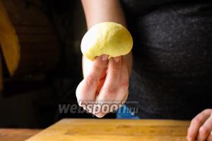 Снова посадите булочку на сложенные пальцы, гладкой стороной к верху. И снова обхватите её пальцами и натяните боковые стороны теста к низу. А затем защипните края. Повторите так 4 раза, пока гладкая поверхность теста не натянется и у вас не получится идеально круглая булочка.