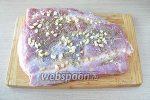 Чеснок порезать на крупные кусочки. Распределить его по всей поверхности грудинки. Высыпать также семена фенхеля, сушёный тимьян и розмарин, втерев специи в мясо. Убрать на 8-12 часов мясо в холодильник, ничем его не накрывая. Оно должно слегка подсохнуть.