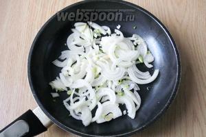 Репчатый лук чистим, моем и нарезаем полукольцами. На сковороду наливаем подсолнечное масло и кладём нарезанный лук.