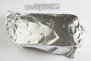Покрываем форму алюминиевой фольгой и прорезаем в ней ножом дырочки для выхода пара. В предварительно прогретой до 200°С духовке выпекаем мясной хлеб 30 минут.