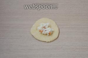 Из каждого кусочка катаем колобок, а затем с помощью скалки формируем лепёшку. На серединку лепёшки выкладываем творожную начинку.