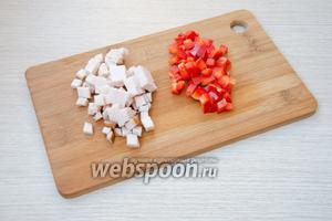 Пока картофель остывает, можно заняться начинкой. Для этого куриное филе необходимо порезать кубиками небольшого размера. Из перца удалить сердцевину и также порезать его небольшими кубиками.