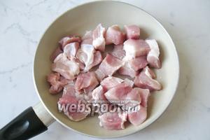 Свинину помыть и нарезать небольшими кусочками, приблизительно 3х4 сантиметра. Обжарить на сковороде с подсолнечным маслом на сильном огне до румяной корочки.