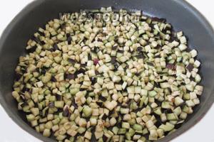 Максимально разогреем сковороду и добавим оставшееся масло. Выложим нарезанные баклажаны на сковороду тонким слоем. Как следует обжарим баклажаны, перемешивая их не очень часто. Примерно раз в минуту.