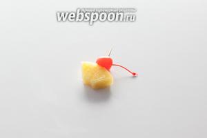 Соединяем коктейльную вишенку с куском ананаса с помощью пики или зубочистки, делаем в нём надрез, чтобы можно было укреплять на бортике бокала.