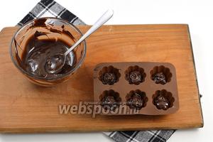 В маленькие формочки для конфет (можно использовать формочки для льда) выложить по 1 столовой ложке шоколада.