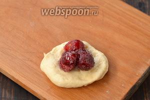 Тесто разделить на куски весом 45 г. Сформировать из каждого куска лепёшку и на середину выложить по 3 крупных черешни без сиропа.