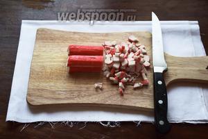 Крабовые палочки нарежем небольшими брусочками. Для экономии времени я беру сразу штук 6-8, нарезаю их продольно, а потом всю эту кучку шинкую. Получается лихо!