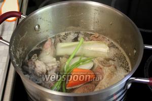 Когда закипит, снять пену и добавить крупно нарезанные коренья (кроме картошки) и стебли зелени, посолить.