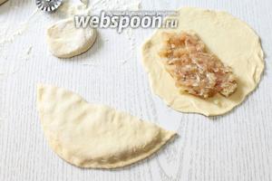 На половину круга выкладываем начинку. Накрываем второй половинкой теста, и, прижимая ладонями тесто к начинке от центра к краям, выгоняем воздух из чебурека и скрепляем прочно края. Можно для верности пройтись зубцами вилки, я обрезаю края роликом.