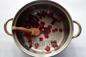 В толстостенной кастрюле разомнём ягоды клюквы! Если ягоды используются замороженные, сначала рекомендуется их немного разморозить!