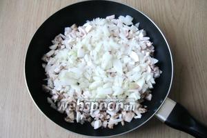 Репчатый лук почистить, помыть и мелко нарезать. Отправить на сковороду к баклажанам и шампиньонам.
