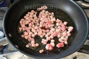 Разогреть сковороду с толстым дном и положить обжариваться кубики бекона, не доливая дополнительно масло!