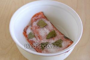 Поместите рыбу кожей вниз в стеклянную или керамическую посуду. Посыпьте солью, сахаром и разломанным на кусочки лавровым листом.